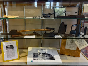 Sad irons and axes in a display case